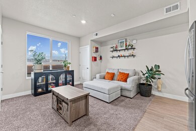 Living room featuring a textured ceiling, recessed lighting, and light wood-style flooring