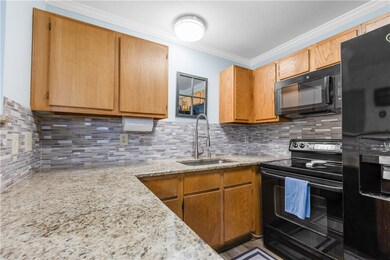 Kitchen with black appliances, tasteful backsplash