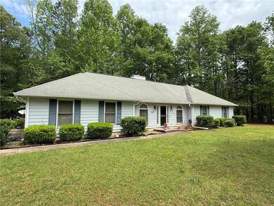 Ranch-style home featuring a front lawn, a shingle