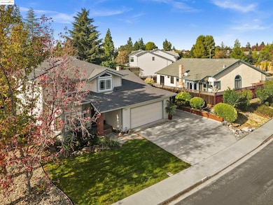 View of front facade featuring concrete driveway, roof with shingles, an attached garage, a chimney, and covered porch