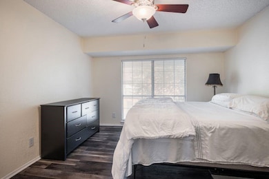 Bedroom featuring a textured ceiling, dark wood-ty