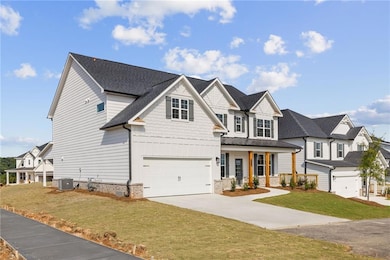 View of front of home featuring covered porch, driveway, board and batten siding, a front yard, and an attached garage
