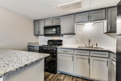 Kitchen featuring black appliances, dark wood-styl