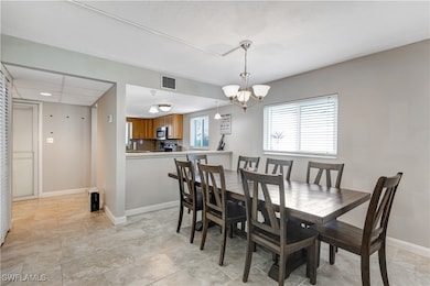 Dining area featuring a chandelier and baseboards