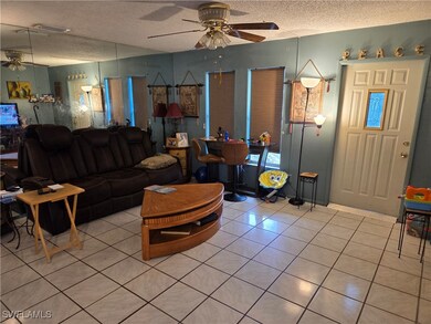 Living room featuring ceiling fan, light tile patt