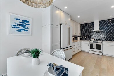 Kitchen featuring decorative backsplash, white cabinets, white appliances, recessed lighting, and extractor fan