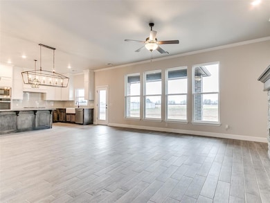 Unfurnished living room with ornamental molding, plenty of natural light, a ceiling fan, light wood-style flooring, and recessed lighting