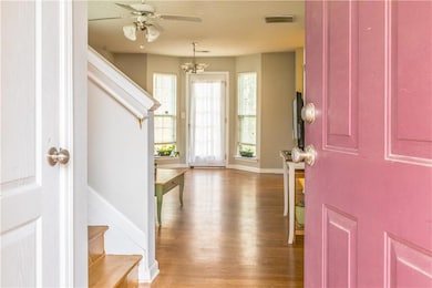 Foyer with stairs, a ceiling fan, baseboards, wood