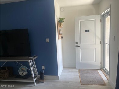 Entryway with a wealth of natural light, wood finished floors, and baseboards