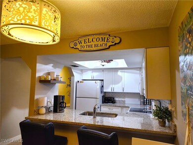 Kitchen featuring tasteful backsplash, light stone