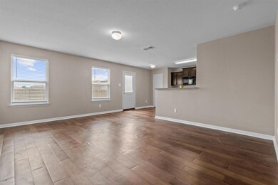 Unfurnished living room with visible vents, baseb