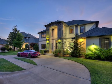 View of front facade featuring a lawn, curved driveway, stucco siding, and stone siding