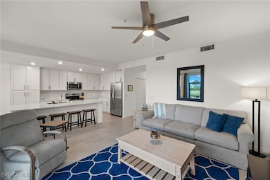 Living room featuring sink, light tile patterned f