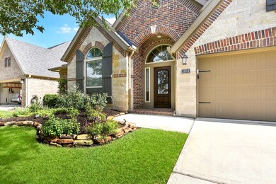 Upgraded exterior elevation featuring brick and stone on a low-traffic street. Professionally landscaped front, back, and side yards enhance the curb appeal. Follow the charming pathway that leads to the arched entryway and its covered porch, inviting you to the front door.