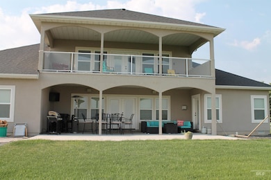 Back of house featuring a balcony, an outdoor hangout area, and a shingled roof