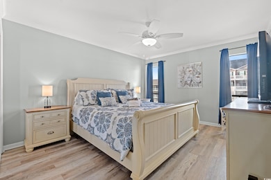 Bedroom featuring ceiling fan, crown molding, and 