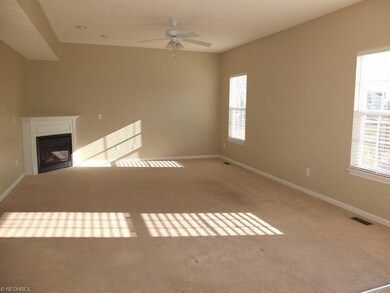 Great room with corner fireplace is open to the di