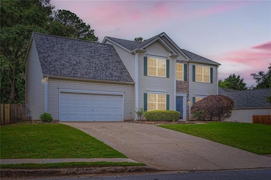 Traditional home featuring concrete driveway, roof