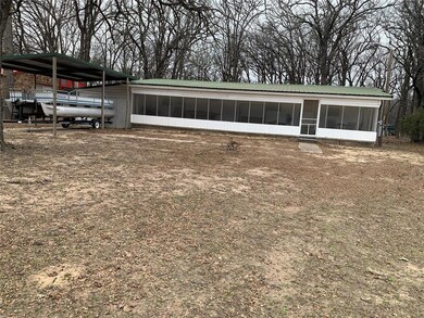 View of front of home with a carport, a sunroom, a
