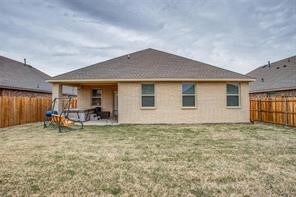 Rear view of house featuring a patio and a fenced backyard