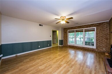 Large family room with ceiling fan. Real brick wal