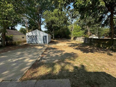 View of yard with a garage and an outbuilding