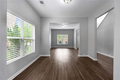 Spare room with dark wood-style floors and baseboa