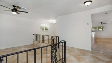 Corridor featuring an upstairs landing, a chandelier, and light tile patterned floors