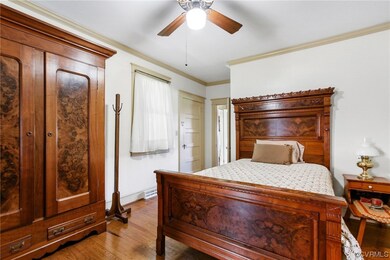 Bedroom with ornamental molding and light hardwood