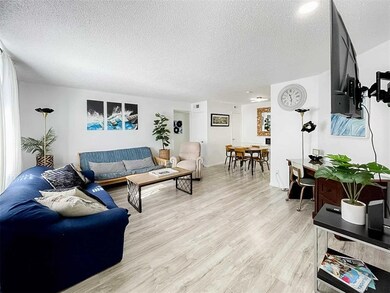 Living area featuring a textured ceiling and light wood finished floors