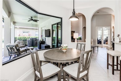 Dining space featuring bay windows, arched walkways, and light tile patterned floors
