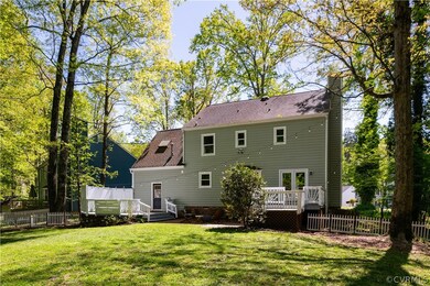 Back of property with a wooden deck and a lawn