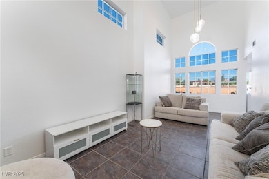 Tiled living room featuring a towering ceiling, ba