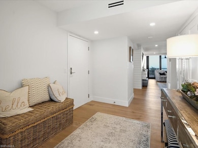 Living area with light wood flooring and recessed lighting