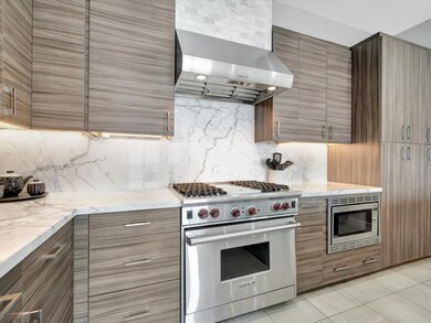 Showcasing Wolf range and hood, custom cabinetry a