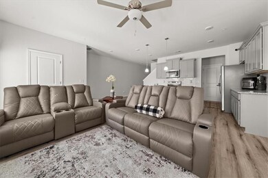 Living area with ceiling fan and light wood-type flooring