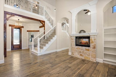 Entryway featuring a fireplace, a towering ceiling, hardwood / wood-style flooring, stairway, and ceiling​​‌​​​​‌​​‌‌​​‌​​​‌‌​​​​​​‌‌‌​​‌​​‌‌​​​‌ fan