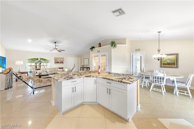 Kitchen with light stone countertops, lofted ceili