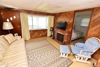 Living area featuring wood walls and a brick fireplace