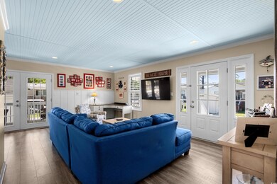 Living room with crown molding, french doors, wood