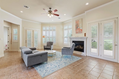 Living room with a ceiling fan, stone tile floori
