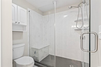 Full bathroom featuring toilet and a marble finish