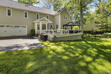 Back of house with a gazebo, a deck, a garage, a y