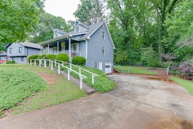 View of front facade with a porch, a garage, and asphalt driveway