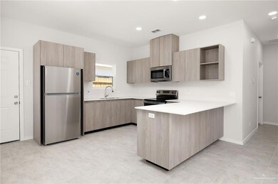 Kitchen featuring stainless steel appliances, a peninsula, light brown cabinets, modern cabinets, and recessed lighting