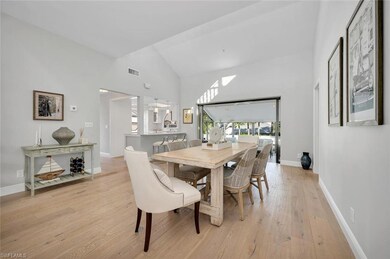 Dining area with light hardwood / wood-style flooring and high vaulted ceiling