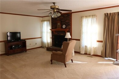 Large den includes wood-burning fire place, chair 