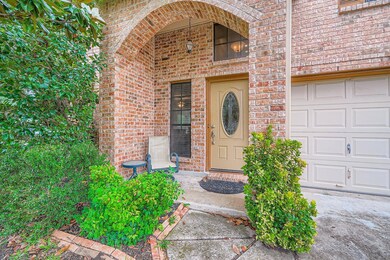 Property entrance featuring a garage and brick si