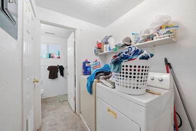 Washroom with a textured ceiling and separate washer and dryer
