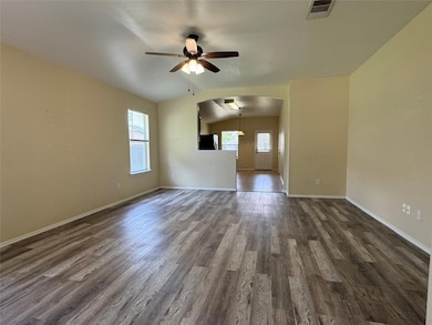 Unfurnished living room featuring ceiling fan, ar